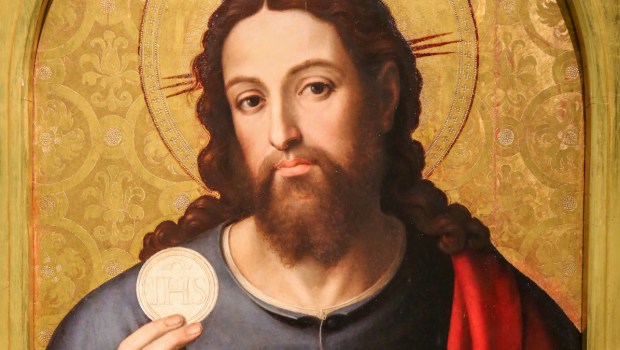 Jezus Chrystus podnosi w dłoni Eucharystię