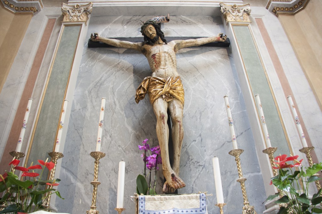 Estatua-de-Jesus-en-la-iglesia-de-San-Nicola-en-prision-Roma.-Crucifijo-de-madera-en-la-pared-decorada.-shutterstock_2017615340-1.jpg