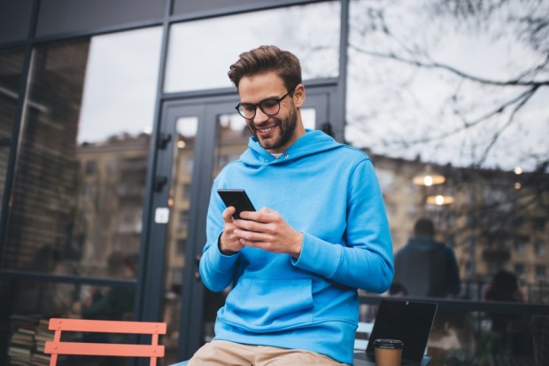 smiling Caucasian male blogger browsing website