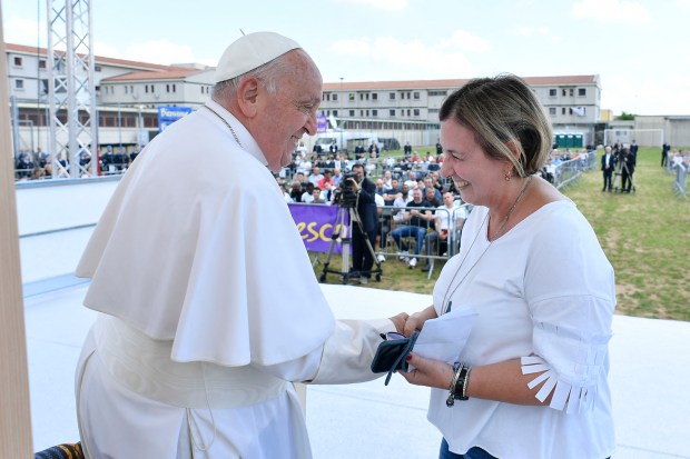 Pope Francis shaking hands with Francesca Gioieni, director of the central prison of Montorio, on the sidelines of a papal visit to Verona