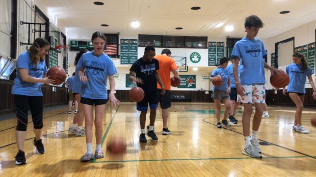 High school students and supervising adults work with young adults with autism at St. Joseph's Church in Maplewood NJ - Dribbling practice