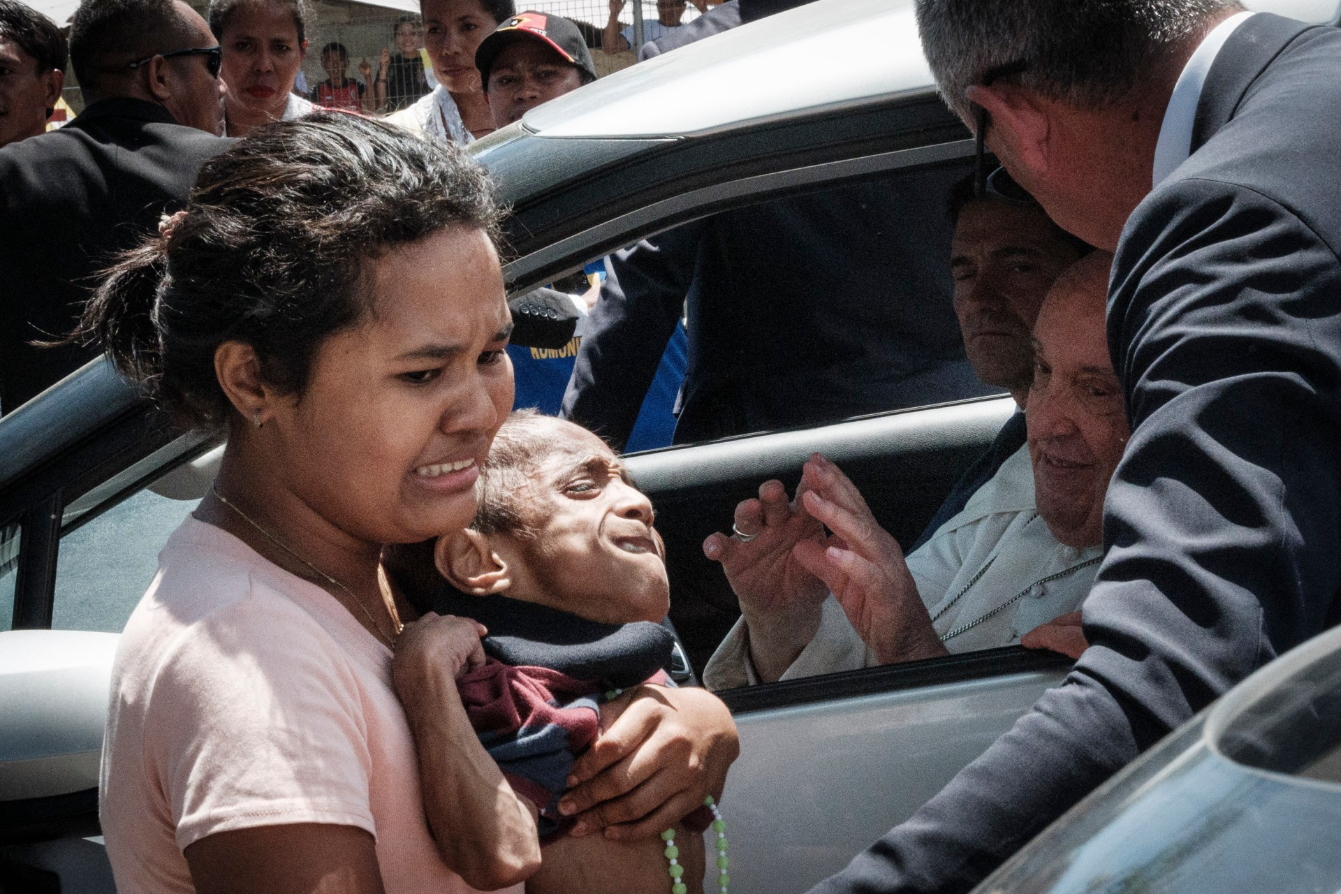 A Catholic faithful and her 9-year-old brother react after being blessed by Pope Francis at the entrance of the Presidente Nicolau Lobato International Airport before his departure to Singapore in Dili