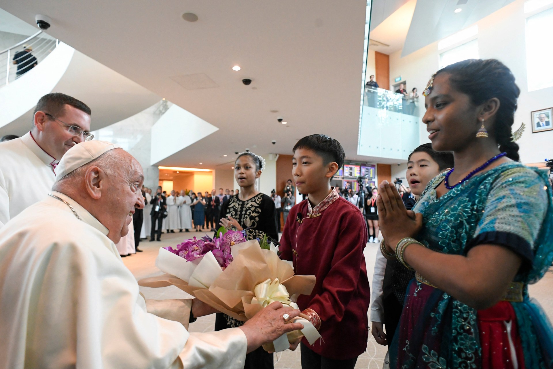 Pope Francis (L) is welcomed upon arrival at Changi airport in Singapore