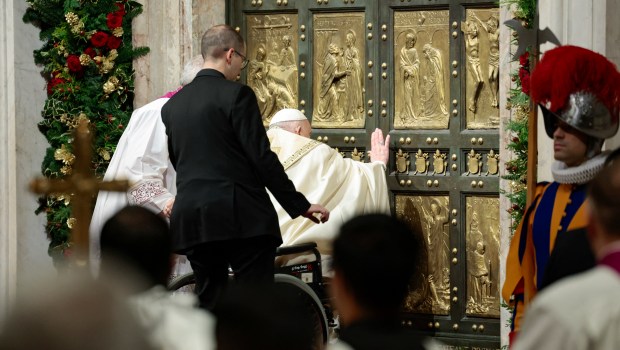 Pope Francis (C) opens the Holy Door of St Peter's Basilica, during a special ceremony to mark the launch of the Jubilee 2025