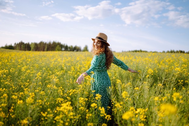 Happy woman walking in flowering field